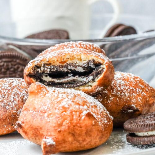 fried oreos on plate dusted with powdered sugar