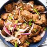 Haitian fried pork topped with pikliz and red onions