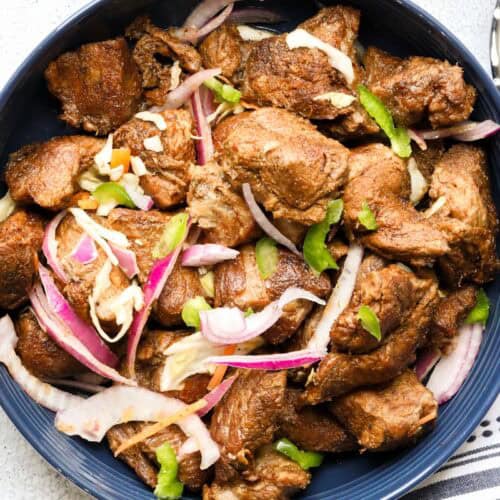Haitian fried pork topped with pikliz and red onions