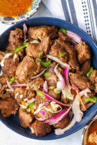 Haitian fried pork topped with pikliz and red onions