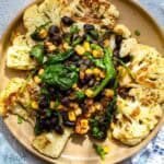 cauliflower steaks toped with black beans, corn, and spinach