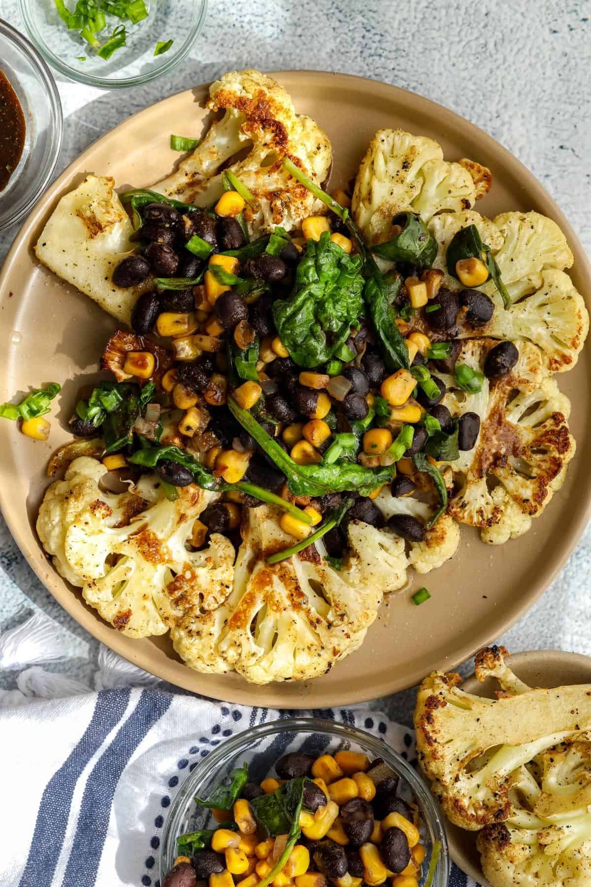 cauliflower steaks toped with black beans, corn, and spinach