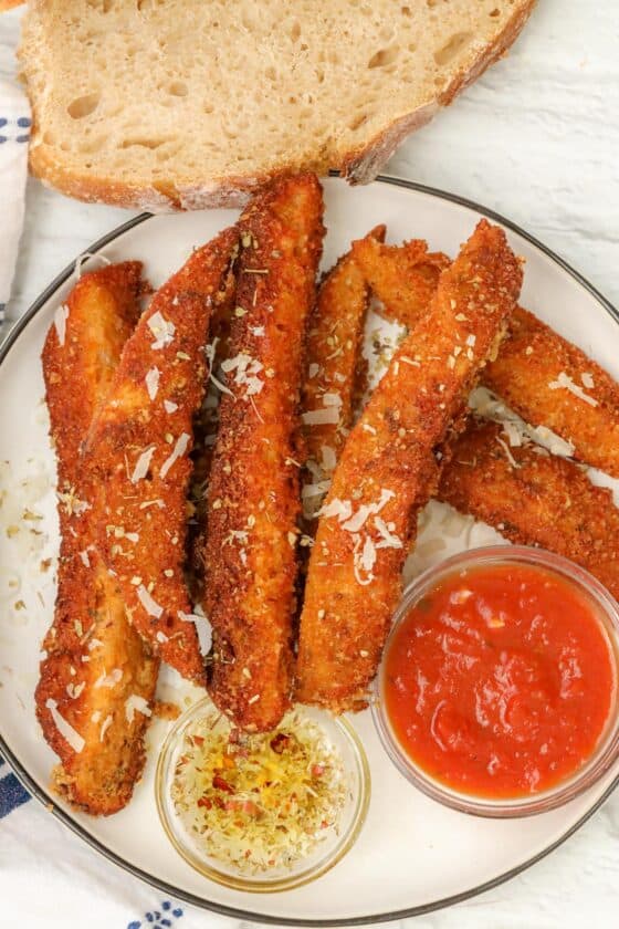 sourdough breadsticks on plate with marinara sauce and olive oil