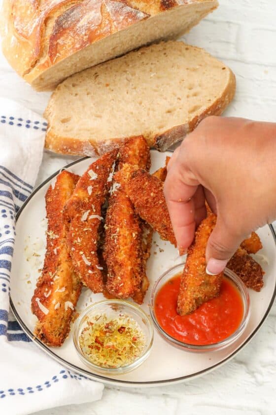 dipping sourdough breadsticks in marinara sauce