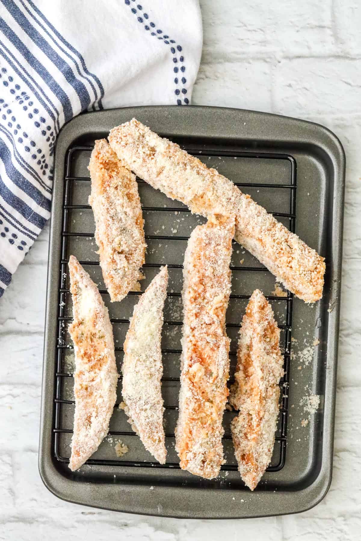 sourdough breadsticks covered with parmesan cheese on wire rack
