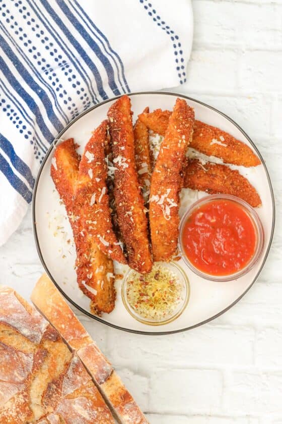 sourdough breadsticks on plate with marinara sauce and olive oil