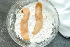 coating chicken strips in flour mixture