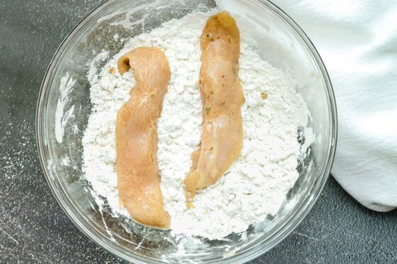 coating chicken strips in flour mixture