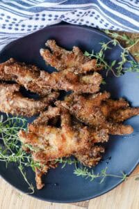 Crispy Fried Chicken Feet Recipe You’ll Love on black plate with thyme sprigs