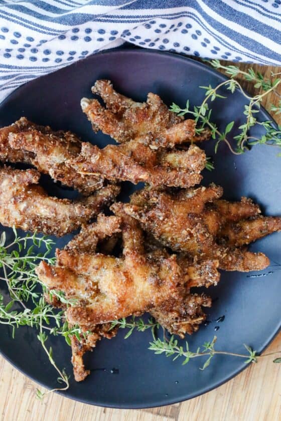 Crispy Fried Chicken Feet Recipe You’ll Love on black plate with thyme sprigs