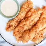 creamy sauce for chicken with fried chicken tenders on white plate