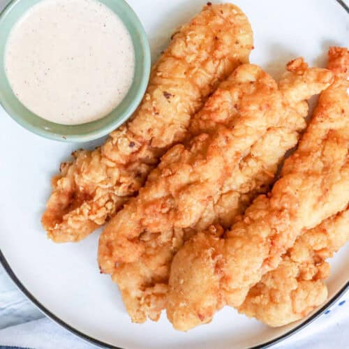 creamy sauce for chicken with fried chicken tenders on white plate