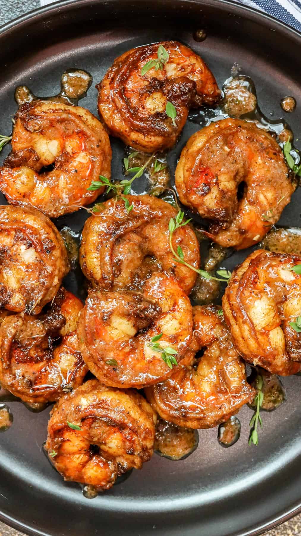 jerked shrimp in black plate with fresh herbs