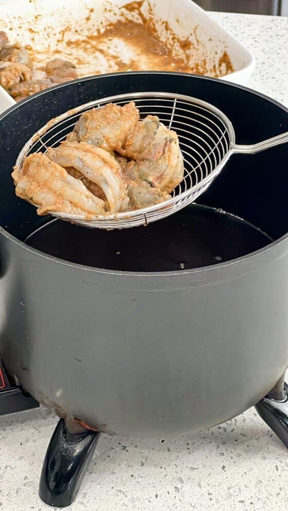 frying black tiger shrimp seasoned with jerk sauce