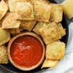 Fried Raviolini on black plate with marinara sauce