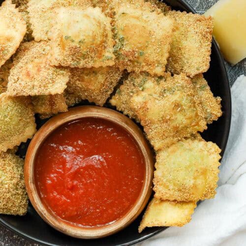 Fried Raviolini on black plate with marinara sauce