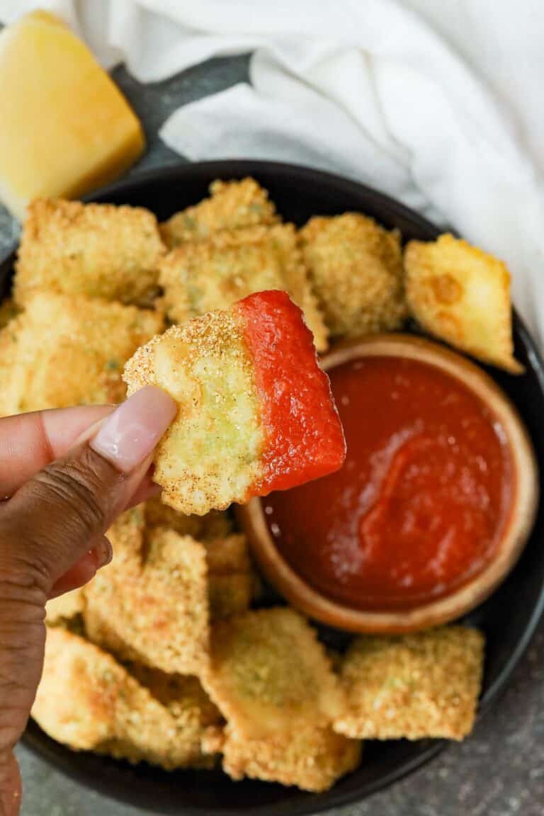 Fried Raviolini on black plate with marinara sauce