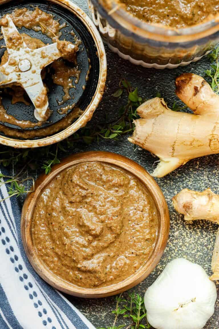 jerk marinade in wooden bowl with ginger and garlic bulb on the side