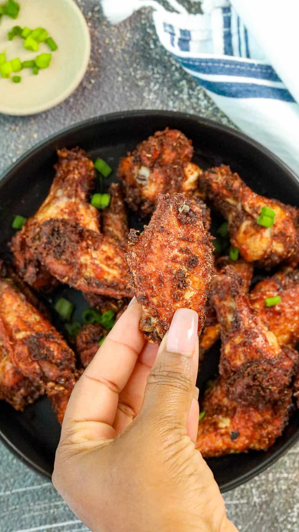 Finger holding chicken wing