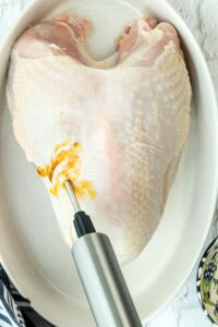 injecting turkey breast with buttery mixture