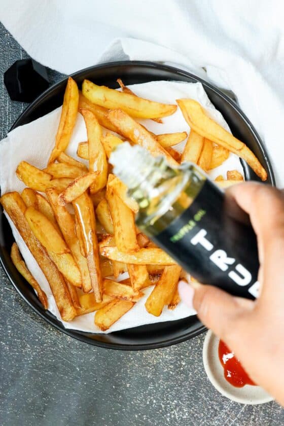 pouring truffle oil over fries
