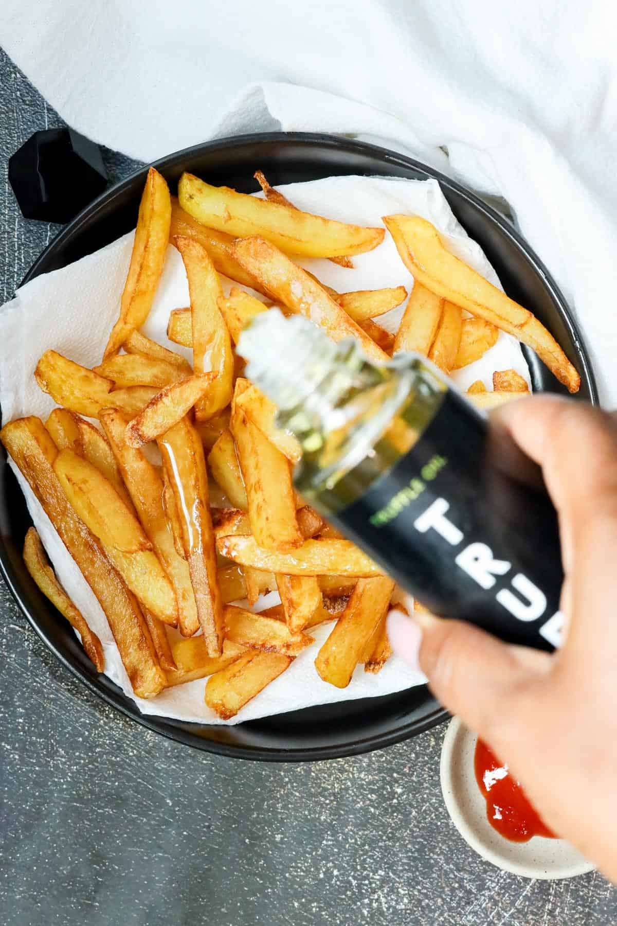 pouring truffle oil over fries