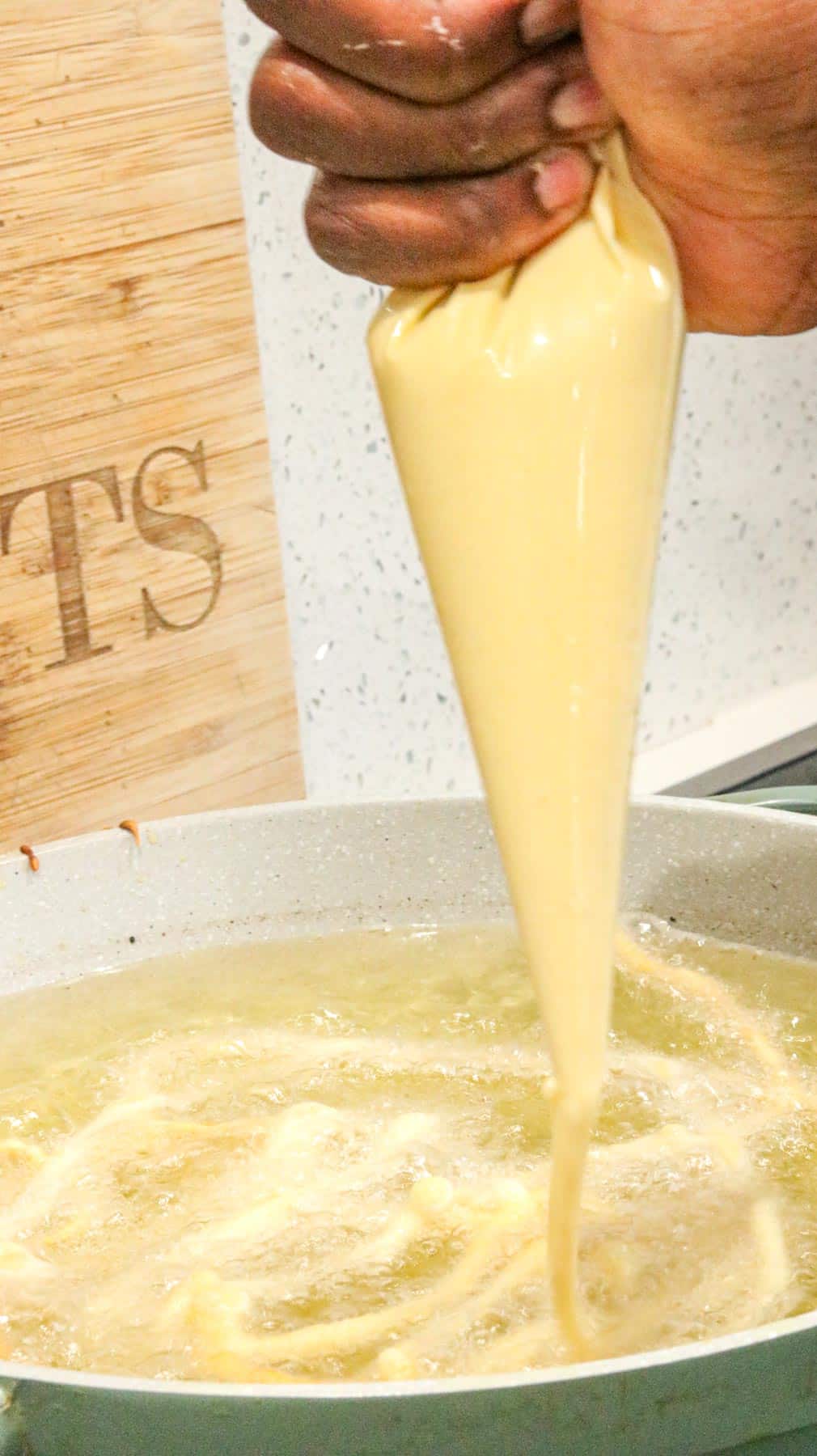 adding funnel cake to heated oil