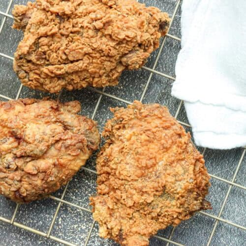fried chicken thighs on cooling rack