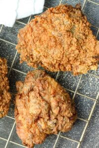 crispy and juicy southern fried chicken thighs on cooling rack