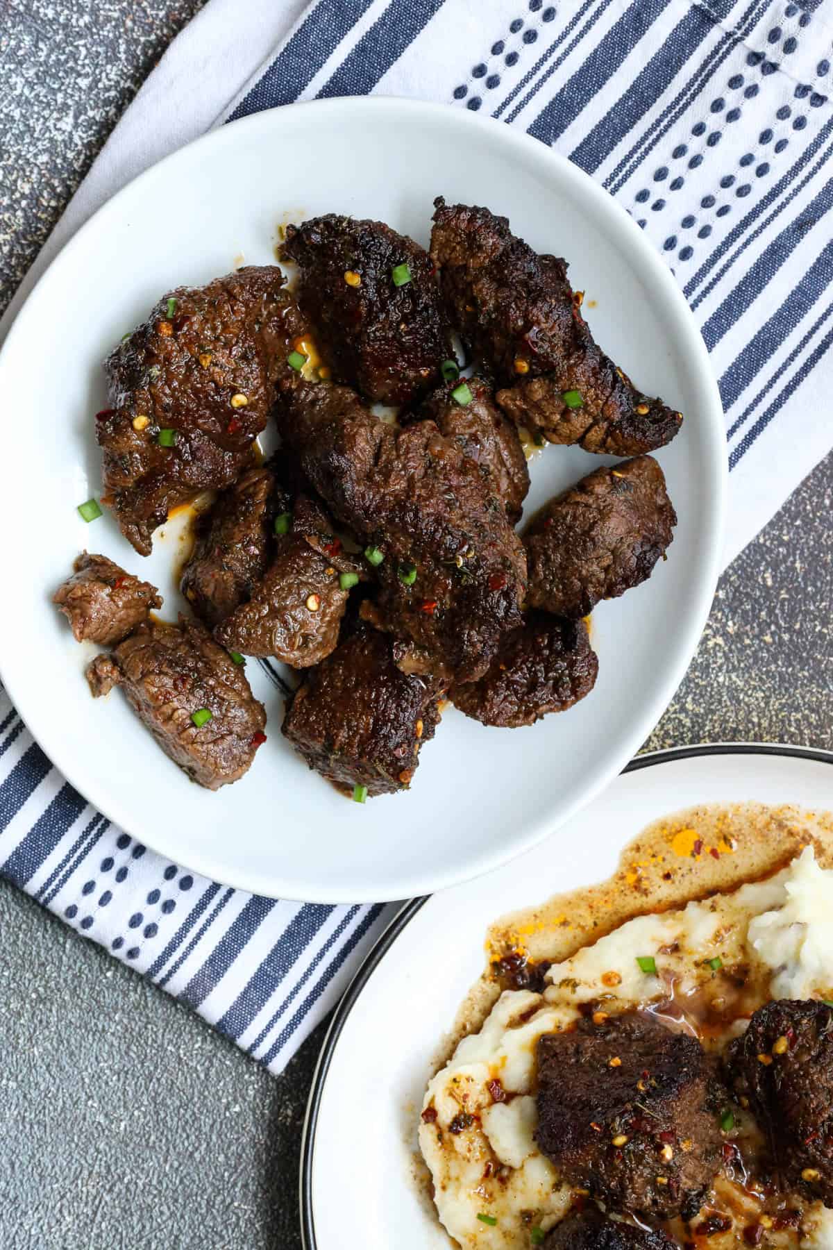 air fryer steak bites topped with chives and red pepper flakes