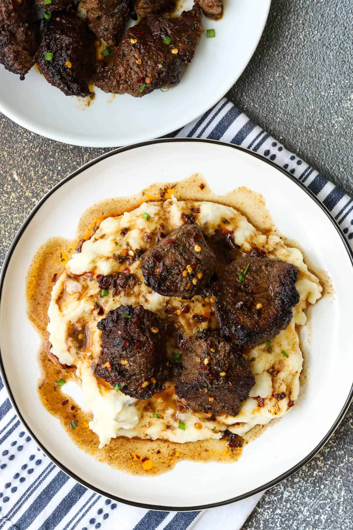 air fryer steak bites over a bed of mashed potatoes