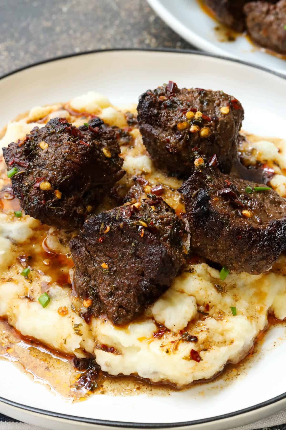 air fryer steak bites on top of creamy southern mashed potatoes