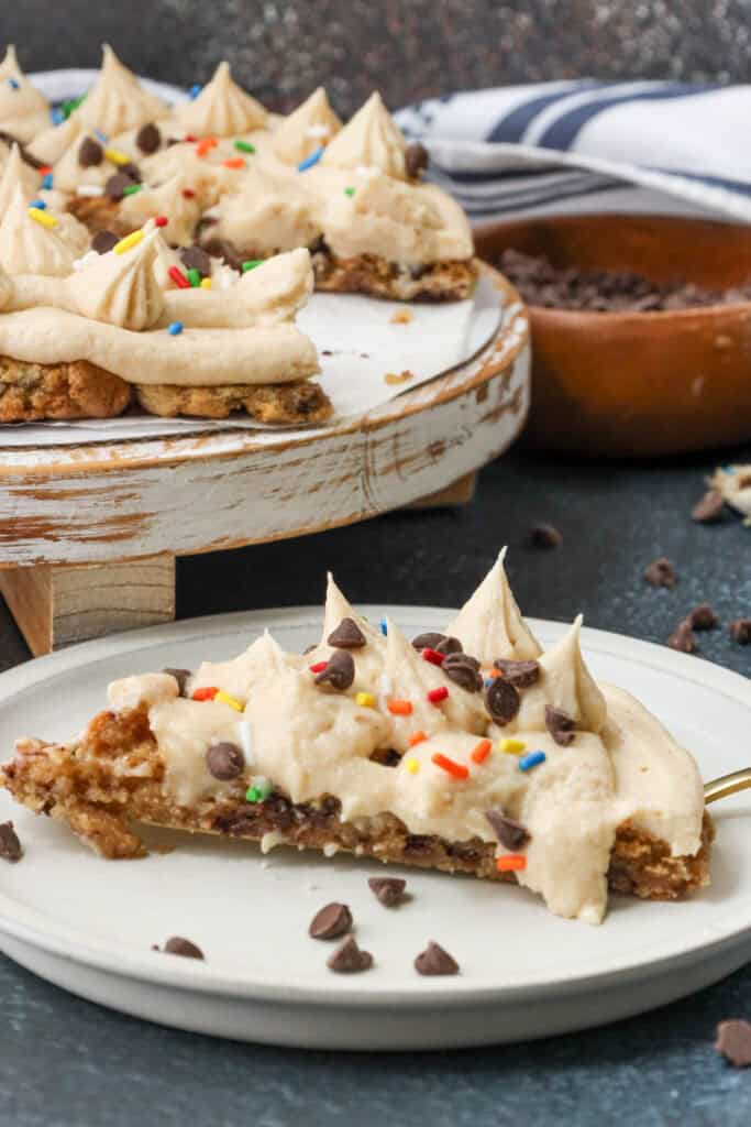 sliced air fryer cookie cake topped with sprinkles and chocolate chips and vanilla frosting
