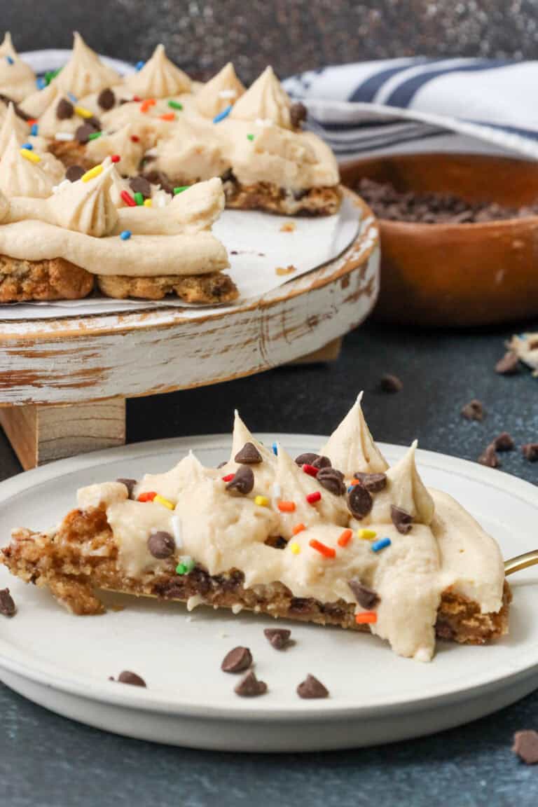 sliced air fryer cookie cake topped with sprinkles and chocolate chips and vanilla frosting