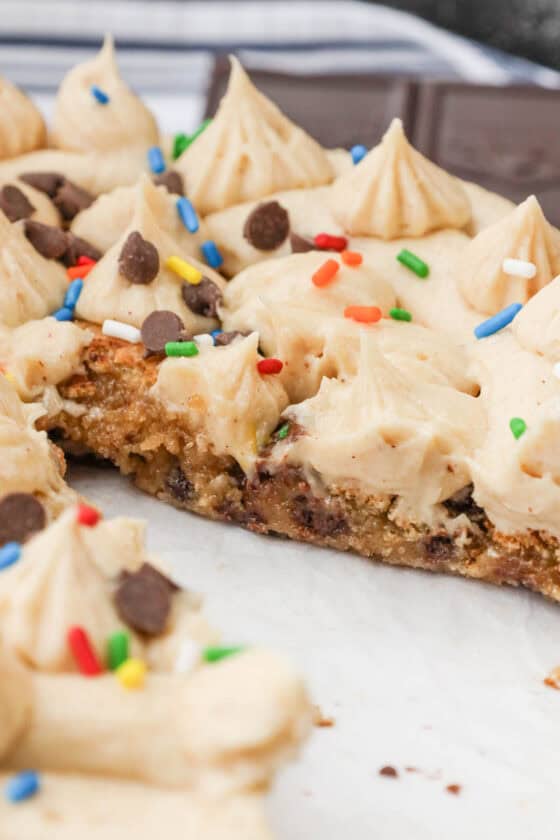 sliced air fryer cookie cake topped with sprinkles and chocolate chips and vanilla frosting