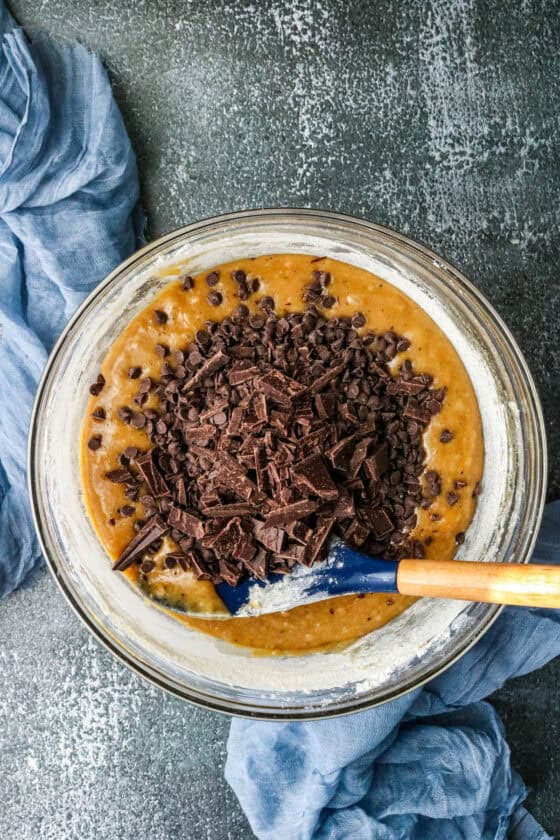 Step-by-step guide to make Air Fryer browned Butter Chocolate Chip Cookies - adding chocolate chips and bars in the mixture
