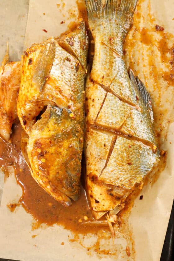seasoned branzino fish on parchment paper