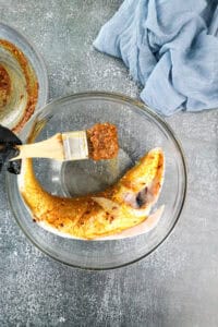 adding seasoning to whole branzino fish