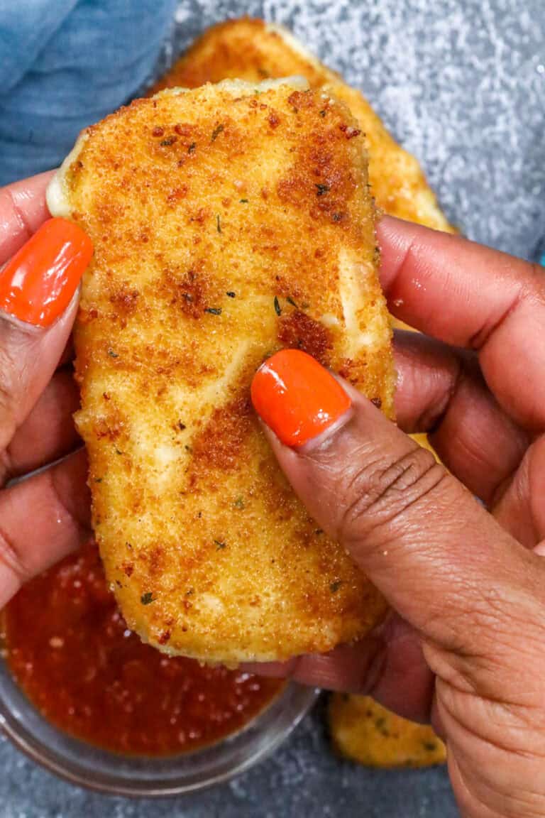 hand holding fried mozzarella cheese