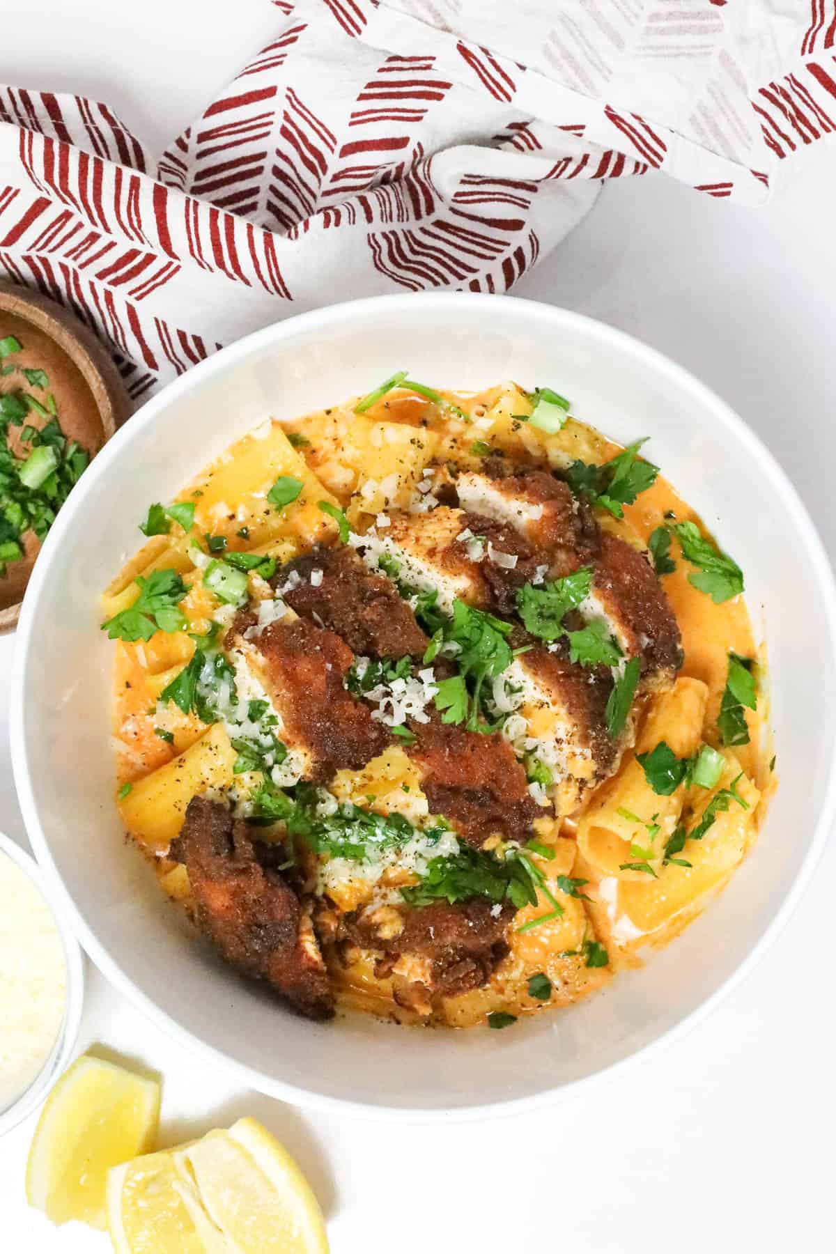 Delicious Gochujang Chicken Breast Recipe over a bed of gochujang pasta and topped with fresh herbs and cheese