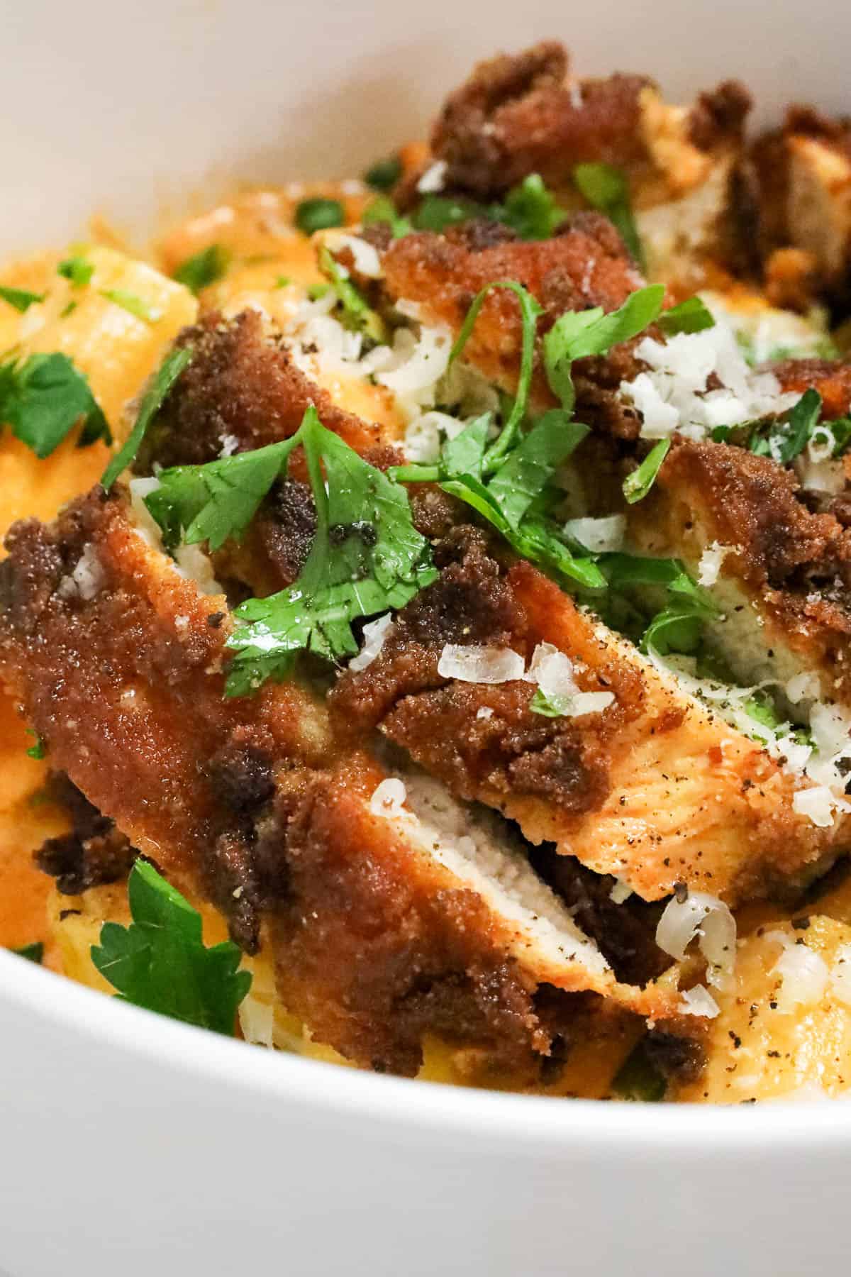 Delicious Gochujang Chicken Breast Recipe over a bed of gochujang pasta and topped with fresh herbs and cheese