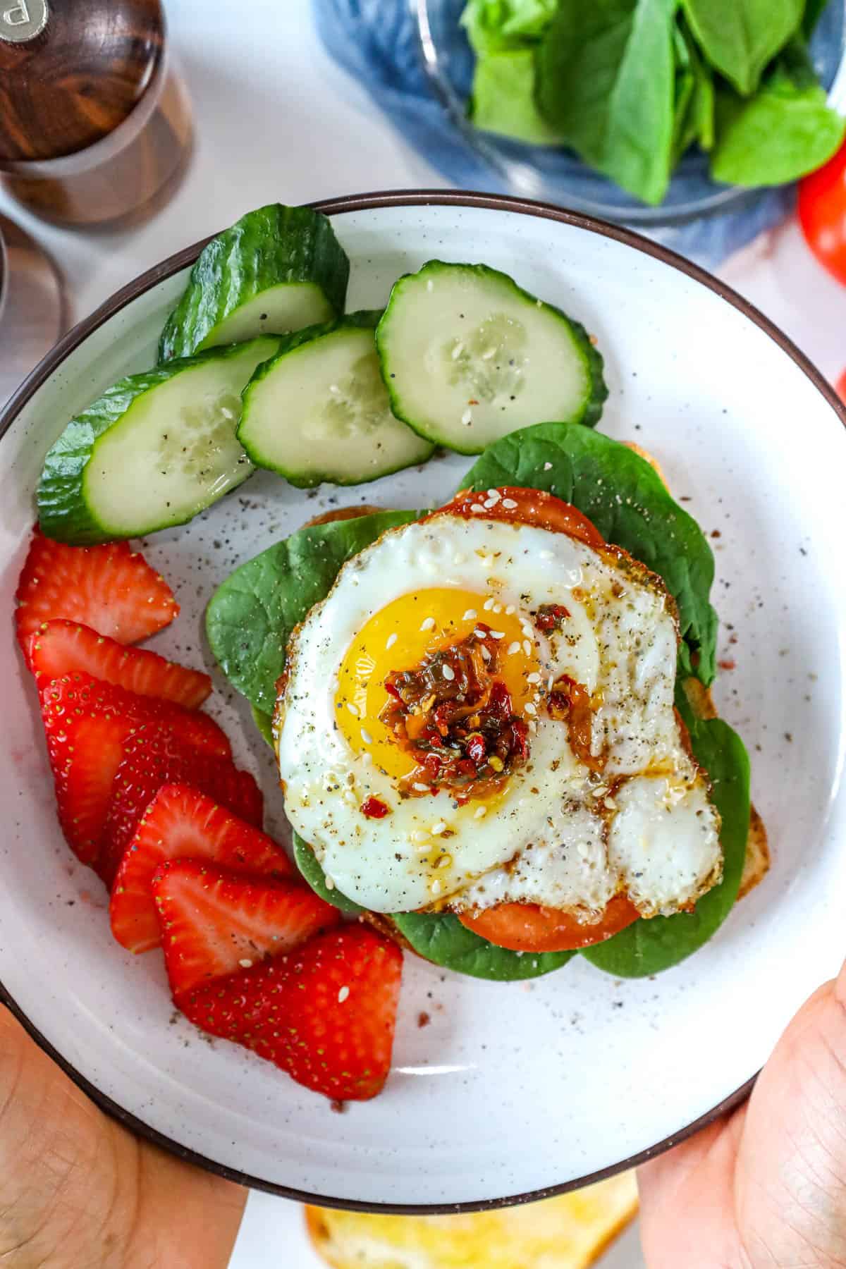 sunny side up fried eggs over a bed or toast with spinach.