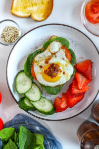 sunny side up fried eggs over a bed or toast with spinach